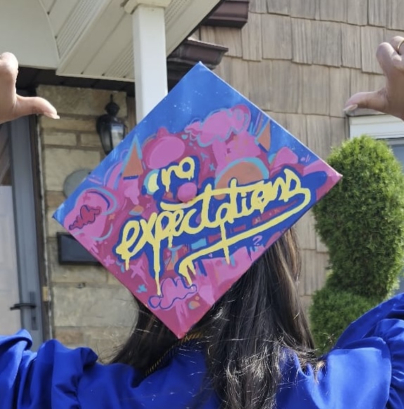 Graduation cap painted with graffiti-style lettering reading no expectations